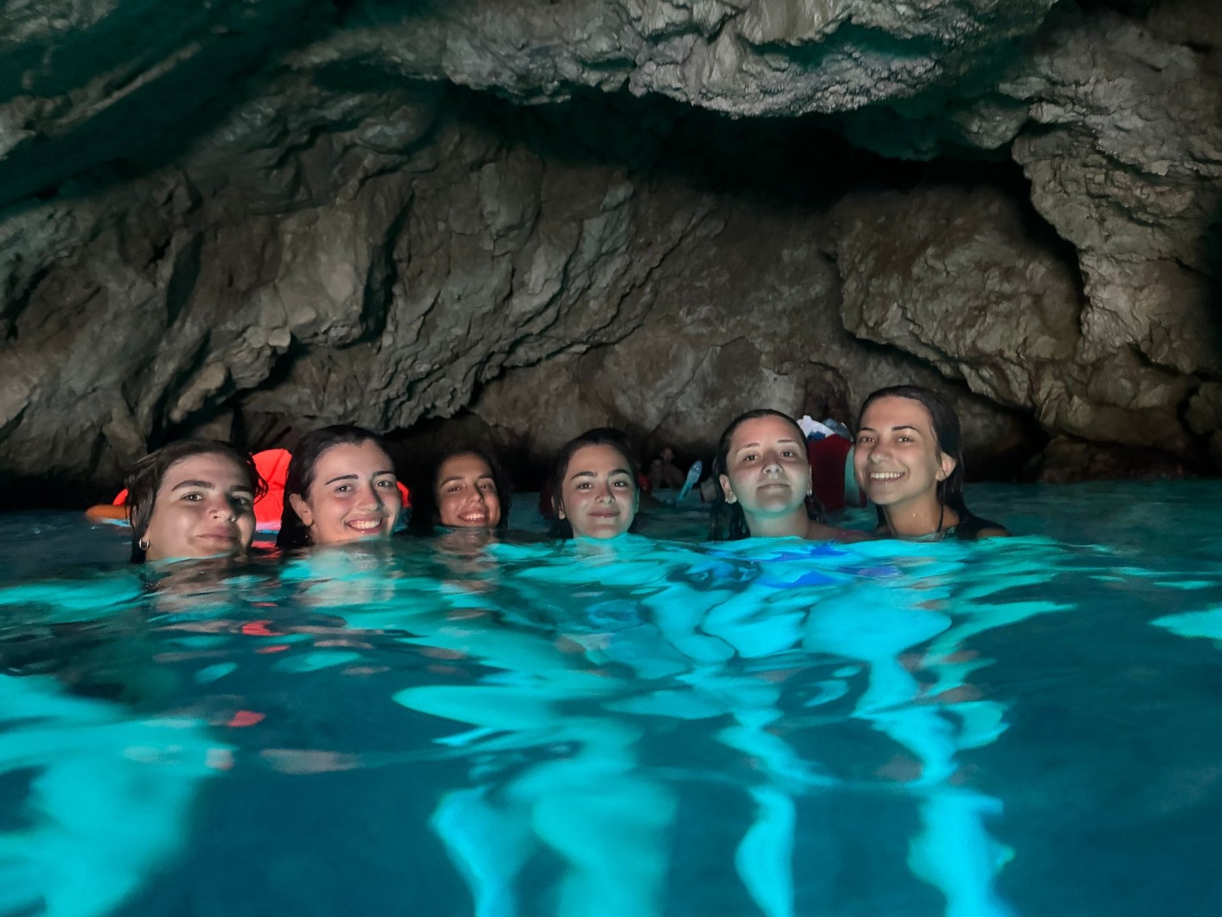 Group swimming inside the Blue Cave on a Garitransfer private boat tour from Dubrovnik, illuminated by vibrant blue Adriatic water.