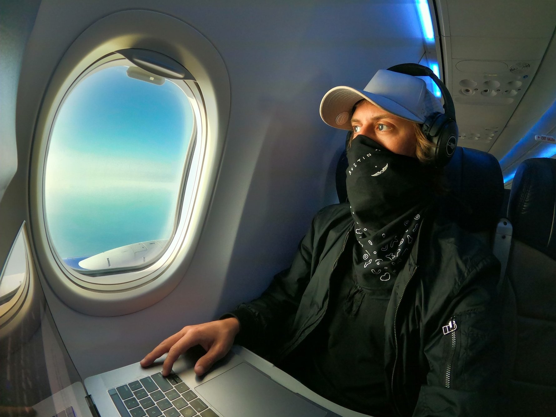 Man on plane looking with mask on © Austin Distel / Unsplash